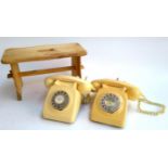 Two rotary telephones with labels for Luton and Bridport, together with a small pine stool, 21.5cmH