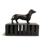 A bronze cage rattle, the handle in the form of a dachshund, 50.5cmL