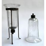 A glass tea light holder on a tripod wrought iron base, 43cmH, with a spare glass holder