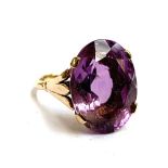 A 9ct gold ring set with a large oval amethyst, the stone 2cm long, size T 1/2, 8.3g