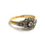 An 18ct gold and platinum ring set with diamond chips in a floral cluster, approx. 2.8g, size K