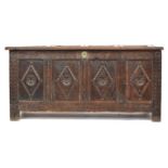 A late 17th/early 18th century four panel oak coffer, demi-lune frieze over lozenge and rosette