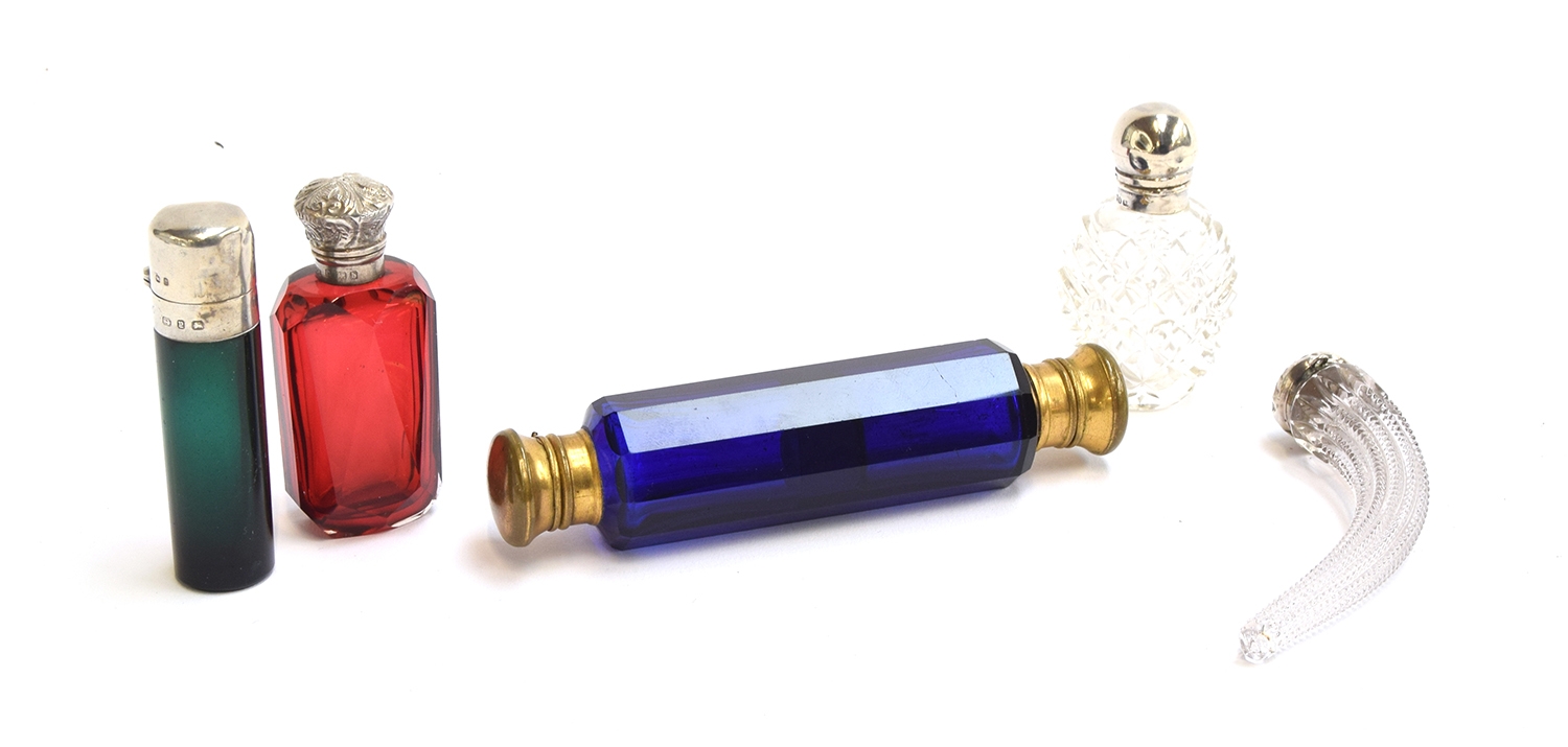 A collection of glass scent bottles to include a faceted cranberry glass scent bottle with chased