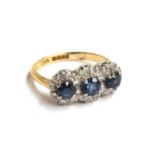 An 18ct gold, sapphire and diamond triple cluster ring, hallmarked 'Albion', size K, approx. 4.2g,