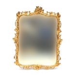 A giltwood mirror, the shaped plate within a carved frame decorated with scrolling foliage, 87x110cm