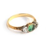 A gold ring set with a cushion cut emerald, approx. 0.6 carats, and two diamonds approx. 4mm