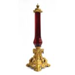 A gilt metal and cranberry glass table lamp in baroque style, 62cm high excluding the fitting
