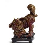 A large early 20th century Chinese sang de boeuf glazed foo dog with puppy, on a carved hardwood