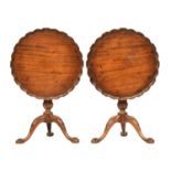 A pair of George II style mahogany tripod tables, each with shaped pie crust tilt top on a gun