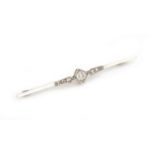 An Art Deco 9ct white gold and diamond bar brooch, the central stone approx. 0.25 carat, approx. 2g