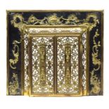 A French brass fire surround c.1900, with openwork doors surrounded by applied scrolling