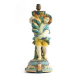A late 19th century Majolica figural table lamp, in the form of a Bacchic youth holding a