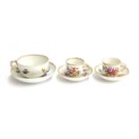 A pair of 19th century teacups and saucers with floral spray decoration, gilt swag decoration to