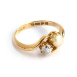 An 18ct gold diamond and pearl crossover ring, the diamond approx. 0.34 carats, size O 1/2,