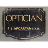 A vintage wooden advertising board, 'Optician, P. J. McCartan F.A.O.I', double sided, 68x91cm