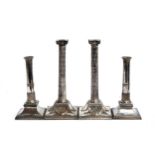 A pair of neo-classical silver plated candlesticks in the form of Corinthian columns on square