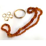 A Baltic amber style necklace; together with four gold tone rings and a gold tone bangle