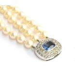 An Art Deco style three strand glass faux pearl necklace with silver and paste clasp, the clasp