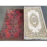 A red ground wool rug, 206x125cm; together with one other, 218x126cm (2)
