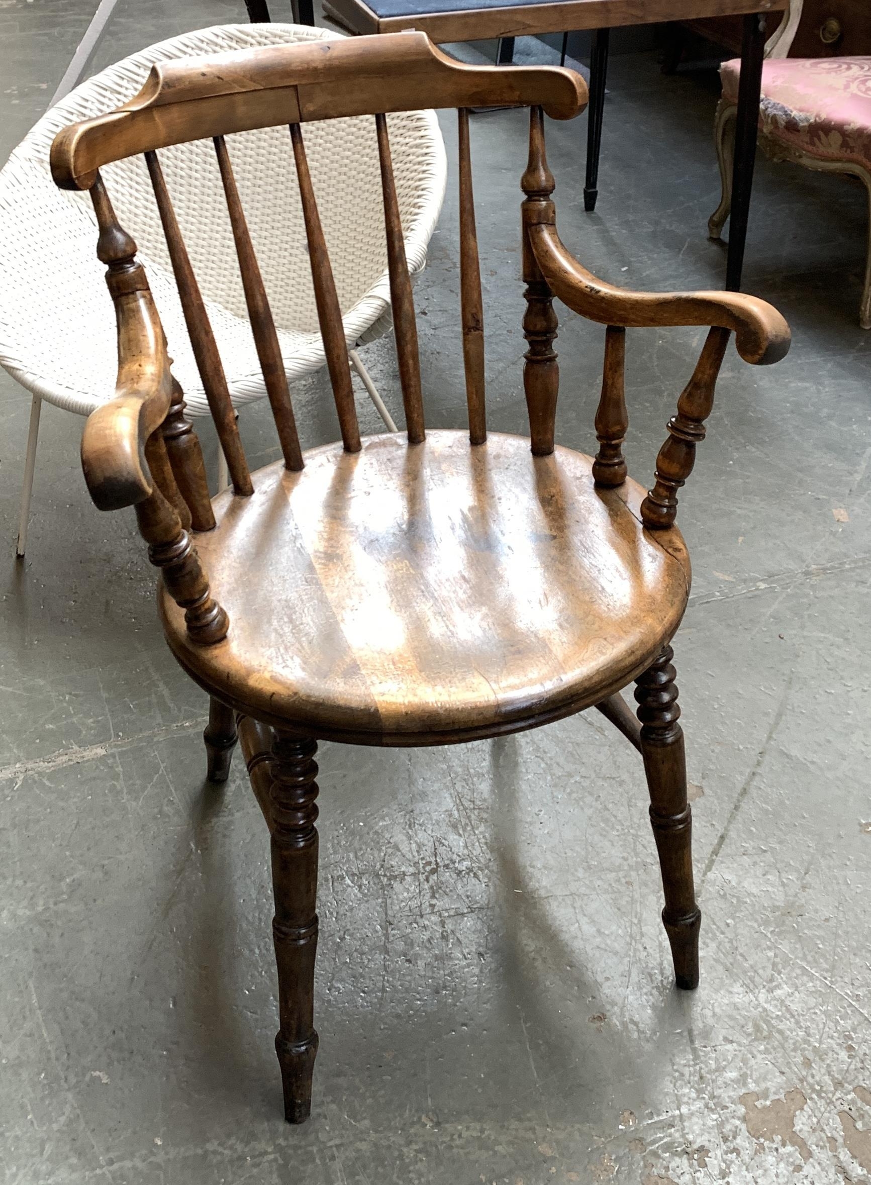 A late 19th/early 20th century captain's chair, turned spindle back on ring turned legs joined by