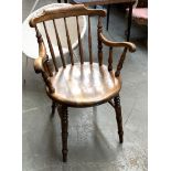 A late 19th/early 20th century captain's chair, turned spindle back on ring turned legs joined by