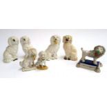Seven Staffordshire poodle figurines, to include one pair and a matched pair, some holding baskets