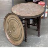 A worked brass Islamic tray, 57cmD; together with a further metal clad circular tray top table, with