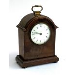 A mahogany cased mantel clock with key, domed top with white enamel dial with Roman numeral and