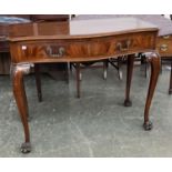 A serpentine fronted console table, in George II taste, two frieze drawers, on carved cabriole