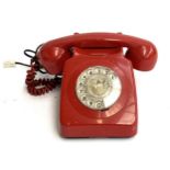 A red rotary dial telephone