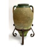 A Mediterranean twin handled oil jar, approx. 59cmH set within a wrought iron stand, approx. 66cmH
