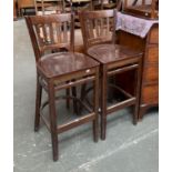 A pair of stained pine barstools, the seats 77cmH