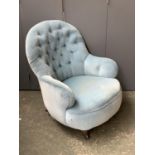 A small Victorian buttonback salon chair, turned legs and ceramic casters