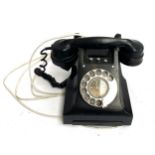 A black rotary dial telephone