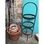 A quantity of terracotta pots and a wrought iron vegetable rack