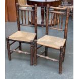 A pair of ash spindle back chairs with rush seats