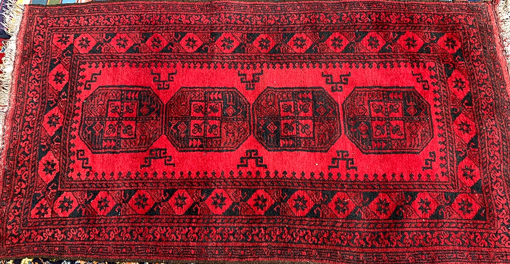 A small red ground Persian rug, 105x195cm