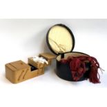 A vintage hat box together with corded curtain tie backs and a small metamorphic sewing box