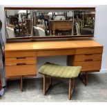 A mid century dressing table, three part mirror and light, kneehole with seven drawers,