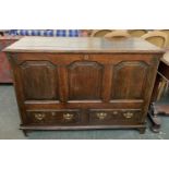 An early 18th century oak mule chest, three panels, with two drawers below, flanked by quarter