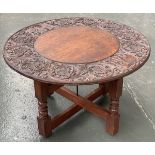 A small Indian occasional table, the top carved with foliage and elephants, 77x47cmH