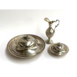 Three white metal items, to include two circular lidded dishes, each with foliate finial, both
