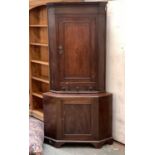 A George III oak corner cupboard, three shelves with drawers below, 80x120cmH, on a later base