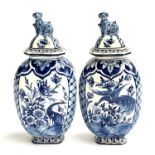 A pair of blue Delft lidded vases, painted with peacocks, each 28cmH