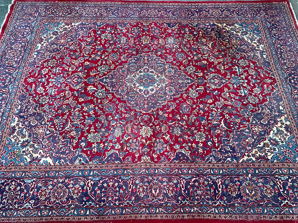 A large red ground rug with central medallion, 390x295cm