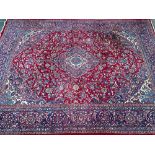 A large red ground rug with central medallion, 390x295cm