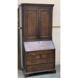 An 18th century oak bureau bookcase, the top with two fielded panel doors, the fall front opening to