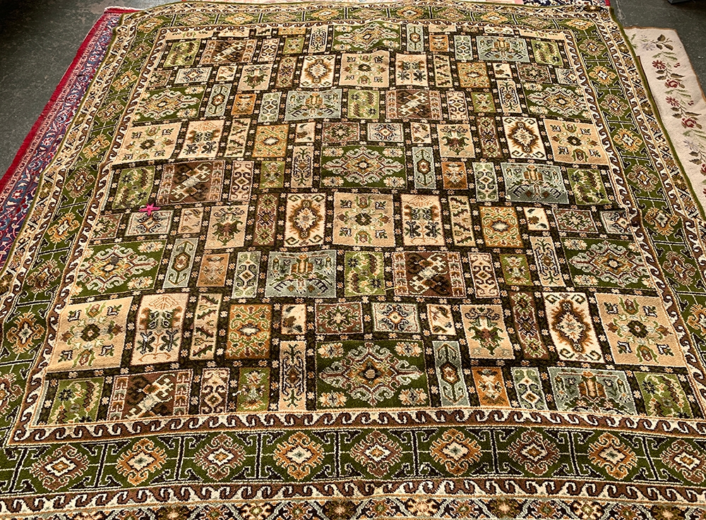 A panelled green rug, 260cm square