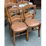 A set of four beechwood kitchen chairs, vinyl upholstered seats and sabre legs, with peripheral