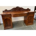 A Victorian mahogany breakfront sideboard, the top with three drawers and carved upstand, on twin